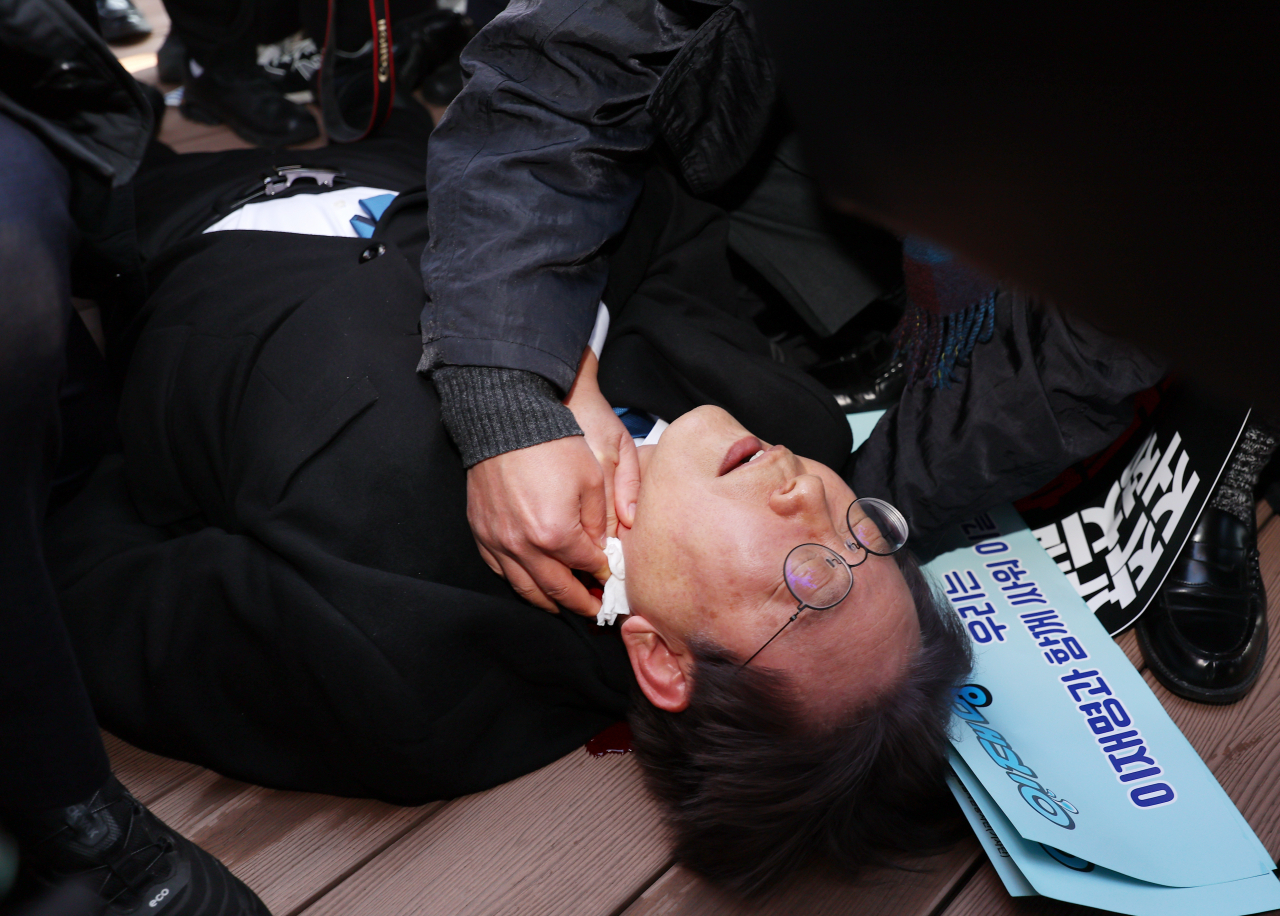 더불어민주당 이재명 대표가 2일 오전 부산 강서구 가덕신공항 부지를 둘러본 뒤 왼쪽 목 부위 피습을 당해 바닥에 누워 병원 호송을 기다리고 있다. [연합뉴스]