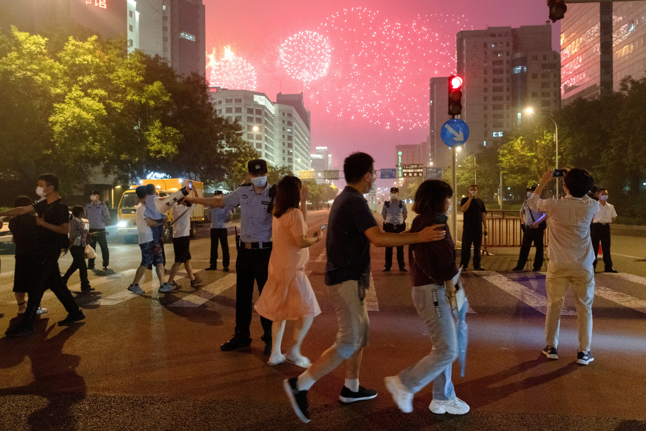 지난 2021년 6월 25일 중국 베이징에서 열린 중국공산당 창당 100주년 기념 행사를 앞두고 사람들이 국립경기장 인근에서 불꽃놀이 리허설을 지켜보고 있다(사진은 기사 내용과 직접적 관련 없음). [로이터]