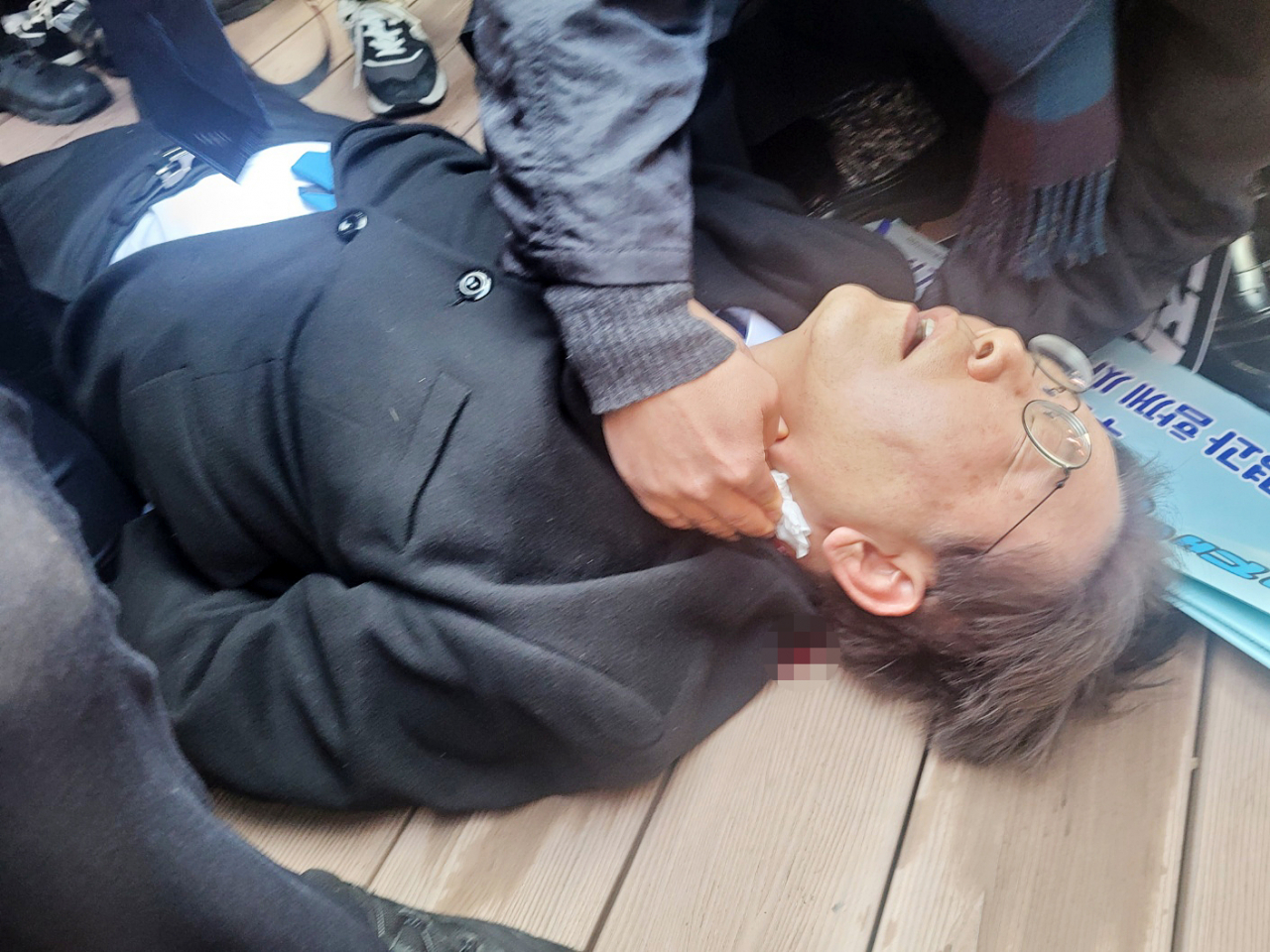 더불어민주당 이재명 대표가 2일 부산 가덕도 신공항부지 방문 중 피습을 당해 바닥에 쓰러져 있다. [연합]