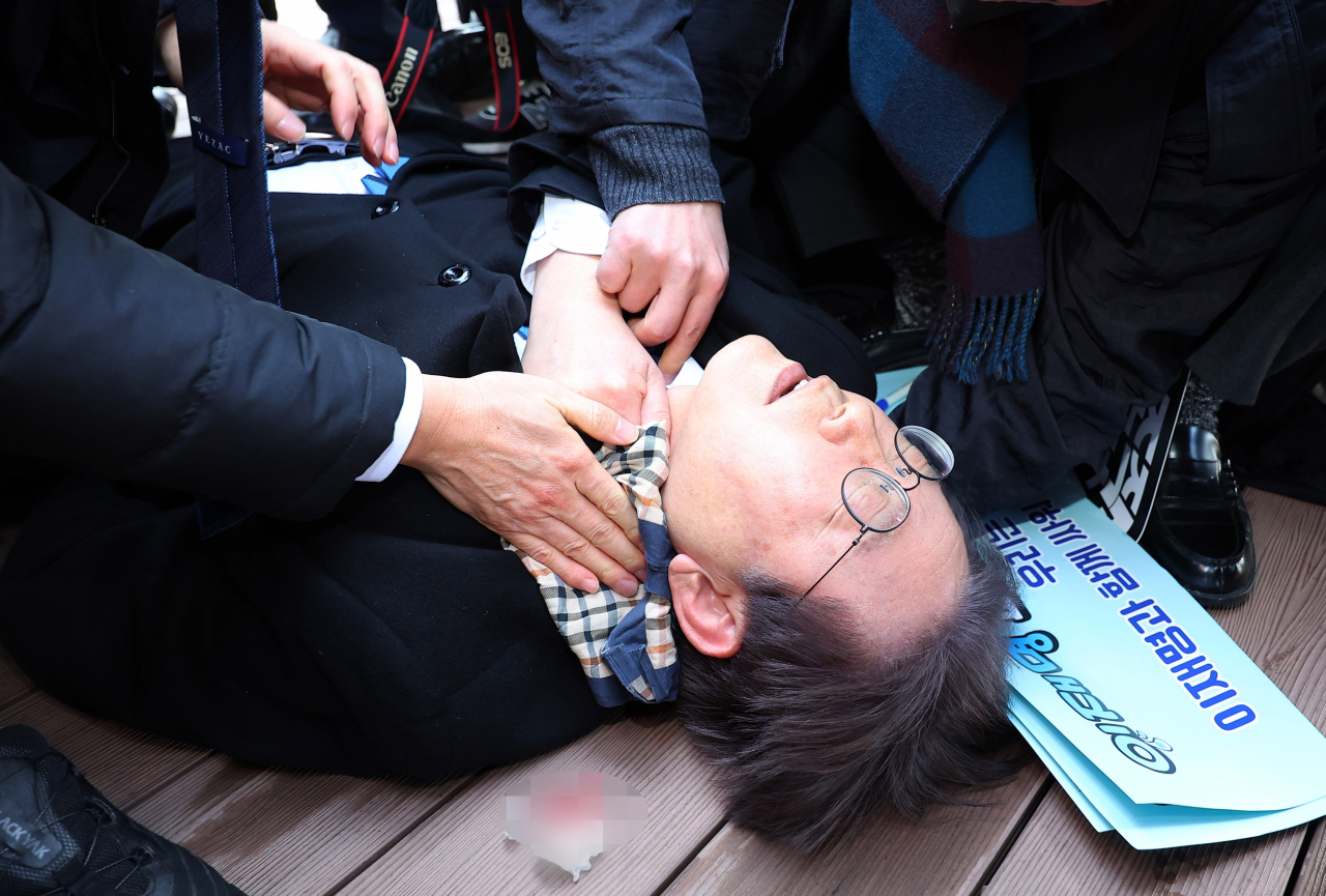 더불어민주당 이재명 대표가 2일 오전 부산 강서구 가덕신공항 부지를 둘러본 뒤 왼쪽 목 부위 피습을 당해 바닥에 누워 병원 호송을 기다리고 있다. [연합]