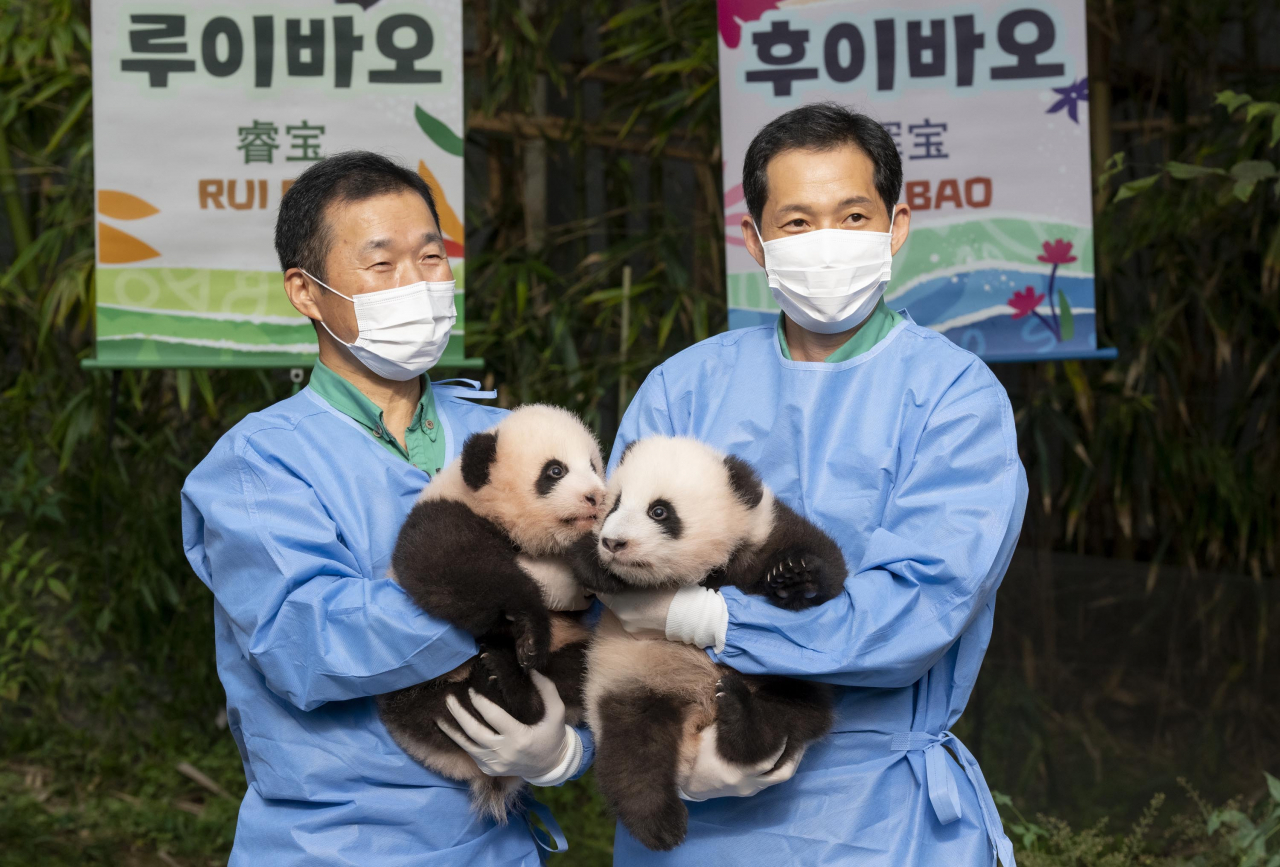 강철원(왼쪽), 송영관 사육사가 쌍둥이 판다를 끌어안아 보이고 있다.