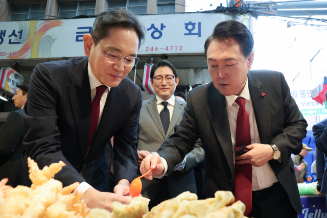 윤석열 대통령과 이재용 삼성전자 회장이 지난달 6일 부산 중구 깡통시장에서 떡볶이, 만두 등 분식을 시식하고 있다. [연합]