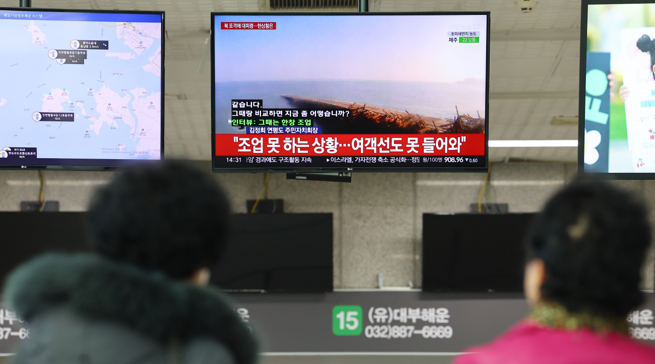 북한의 해안포 사격으로 서해 최북단 백령도와 연평도에 주민 대피령이 내려진 지난 5일 오후 인천 중구 인천항연안여객터미널에서 시민들이 관련 뉴스를 시청하고 있다. [연합]
