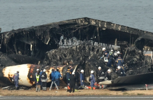 일본 도쿄 경찰 수사관들이 3일 하네다공항에서 일본항공(JAL) 여객기의 잔해를 살펴보고 있다. [연합]