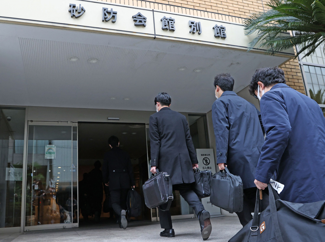 일본 집권 자민당의 '비자금 스캔들'을 수사 중인 도쿄지검 특수부 관계자들이 지난달 19일 도쿄에 있는 자민당 파벌 사무실에 들어가고 있다. 일본 검찰은 이날 자민당 최대 파벌 '아베파'와 다섯번째 파벌 '니카이파'에 대해 정치자금법 위반 혐의로 압수수색을 벌였다. [연합]