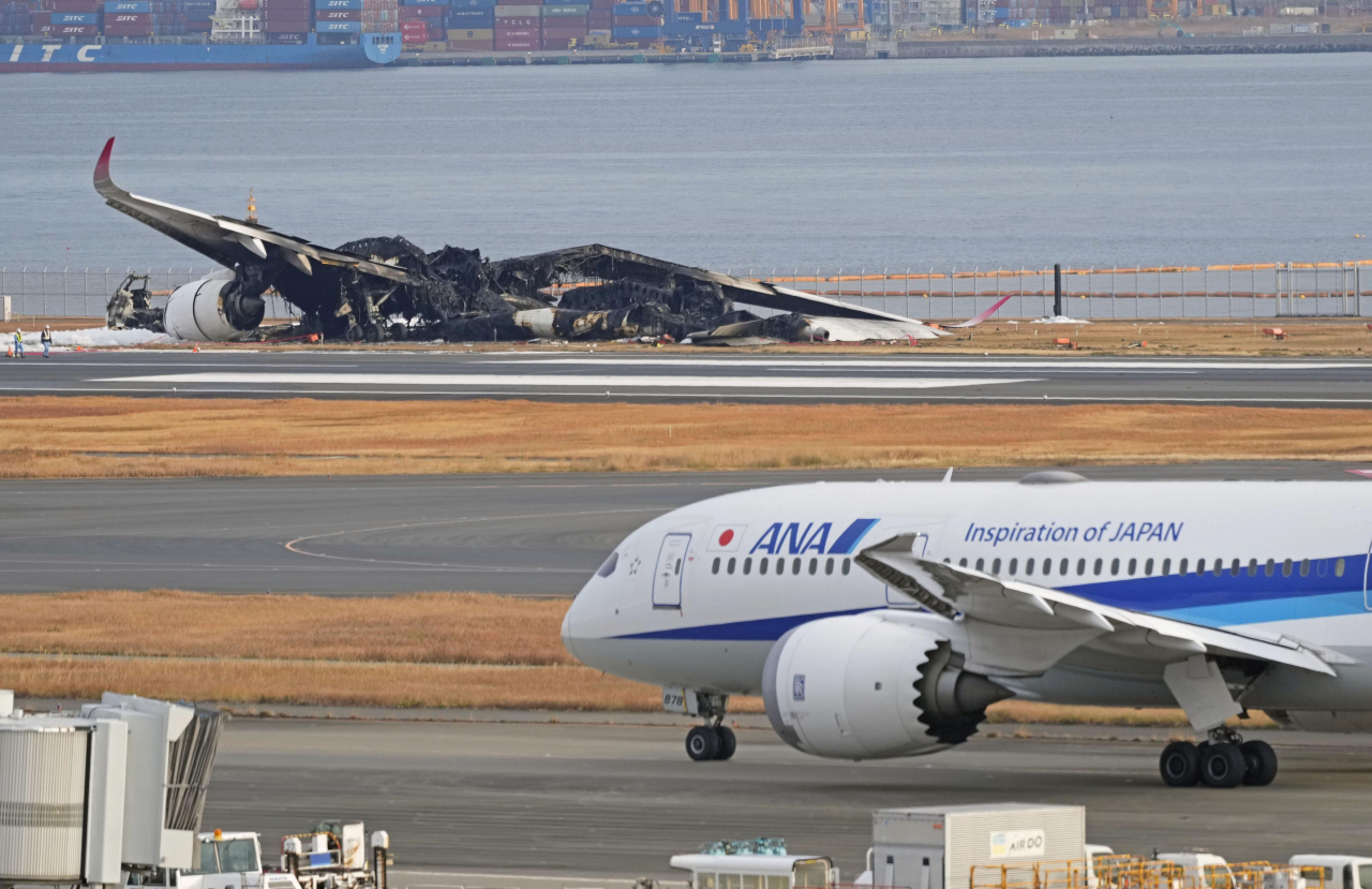 3일 일본 하네다 공항 활주로에 일본항공(JAL) 소속 항공기가 불에 타 있다. [연합]