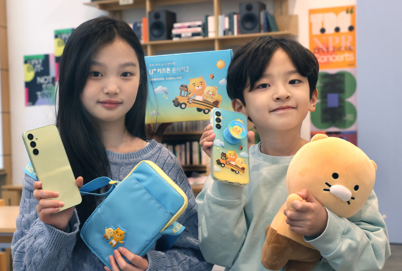 LG유플러스 모델이 카카오 인기 캐릭터 ‘라이언’과 ‘춘식이’ 테마를 적용한 아동 전용 LTE 스마트폰 ‘춘식이2’와 캐릭터 액세서리를 소개하고 있는 모습. [LG유플러스 제공]