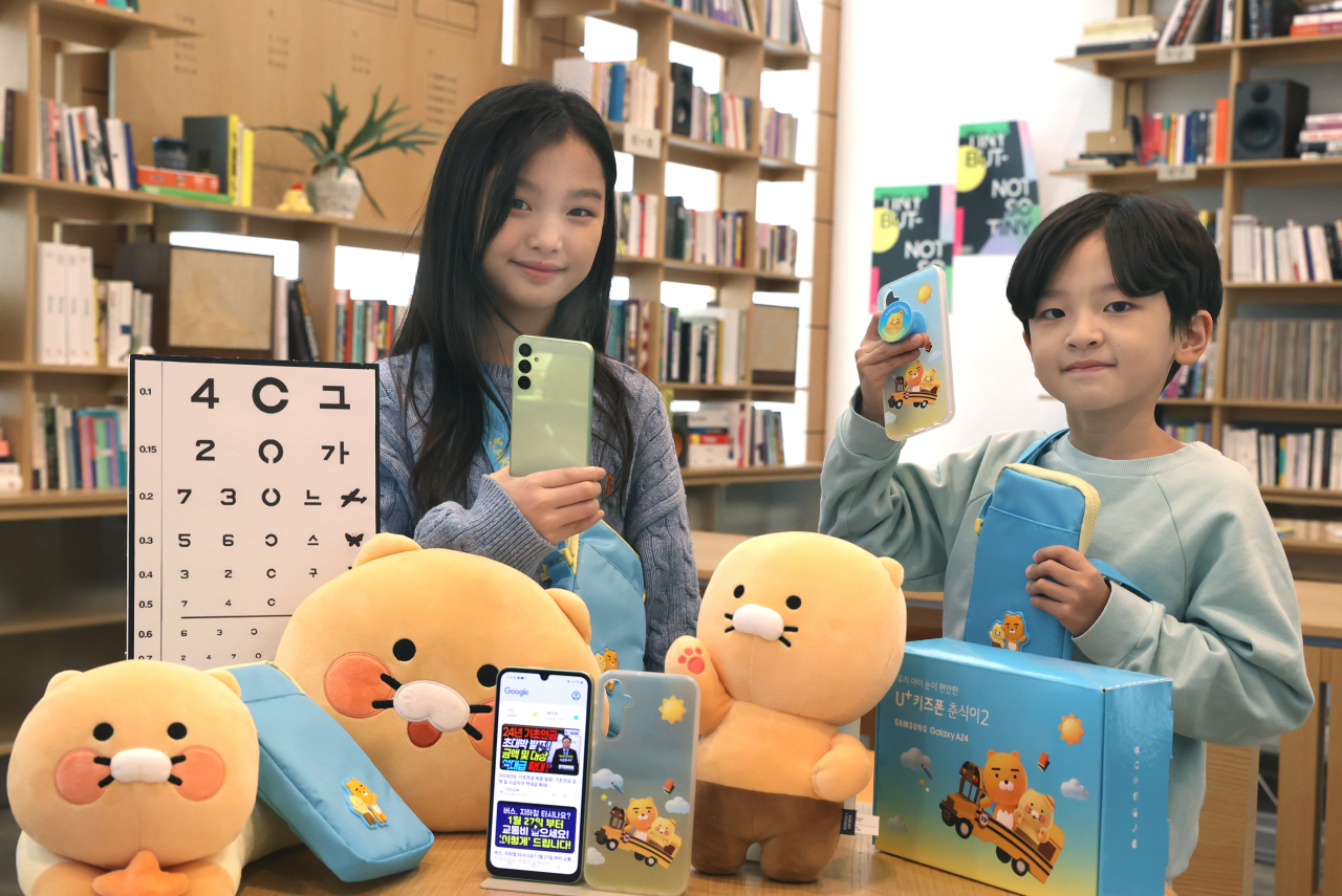 LG유플러스 모델이 카카오 인기 캐릭터 ‘라이언’과 ‘춘식이’ 테마를 적용한 아동 전용 LTE 스마트폰 ‘춘식이2’와 캐릭터 액세서리를 소개하고 있는 모습. [LG유플러스 제공]