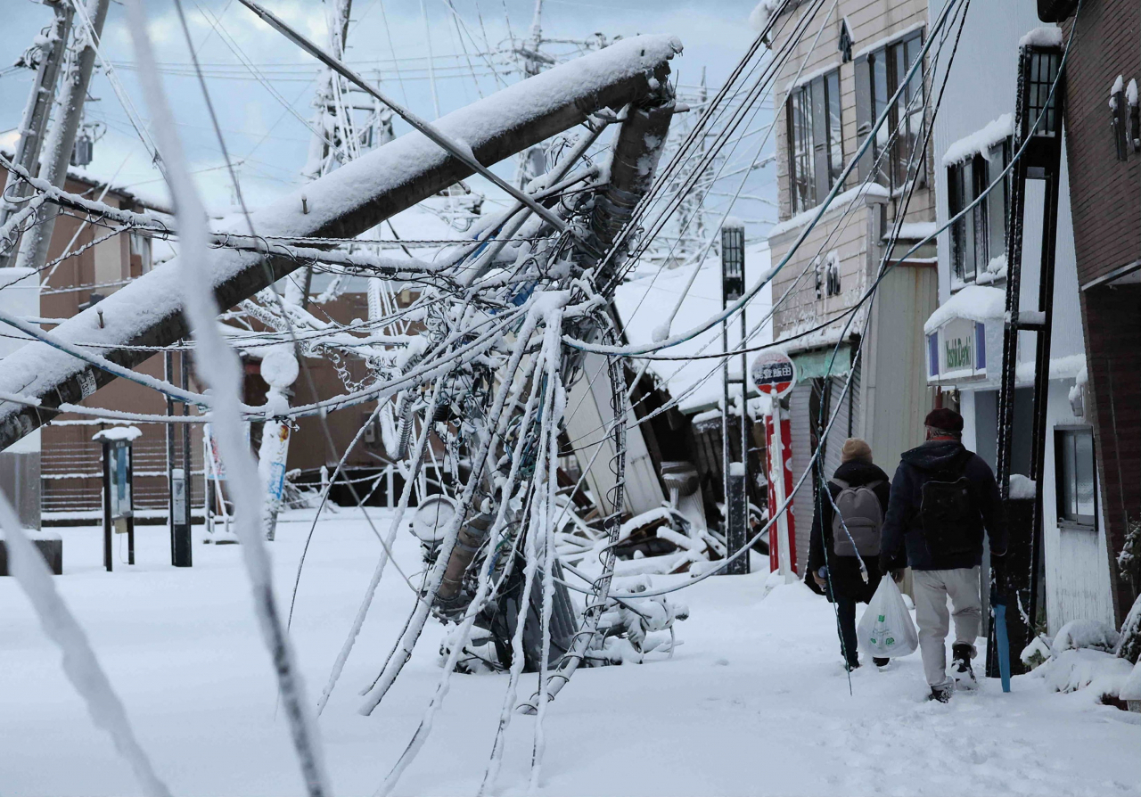 일본 이시카와현 노토반도에서 지난 8일 사람들이 눈으로 덮인 지진 피해 지역을 걷고 있다. [AFP]