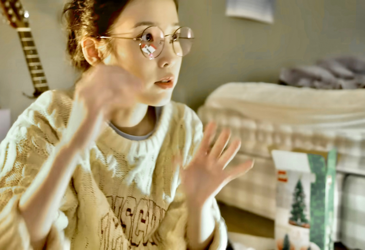 아이유가 공개한 V로그 영상 가운데, 침실에서 스웨덴 브랜드 해스텐스(H&auml;stens) 침대가 포착된 모습. 아이코닉한 체크 패턴 디자인이다. 평소 불면증을 겪는 아이유가 숙면을 위해 선택한 침대로 대중의 관심을 샀다. [유튜브 '아이유TV']