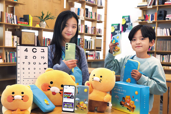 LG유플러스 모델들이 카카오 인기 캐릭터 ‘라이언’과 ‘춘식이’ 테마를 적용한 아동 전용 LTE 스마트폰 ‘춘식이2’와 캐릭터 액세서리를 소개하고 있다. [LG유플러스 제공]