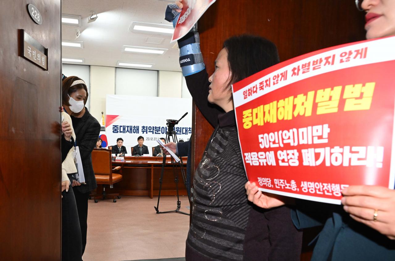 27일 오전 서울 여의도 국회에서 열린 중대재해 취약분야 지원대책 당정협의회 회의장 앞에서 고 김용균 노동자의 어머니 김미숙 씨와 강은미 정의당 의원 등이 중대재해처벌법 관련 팻말을 들고 있다. 이상섭 기자