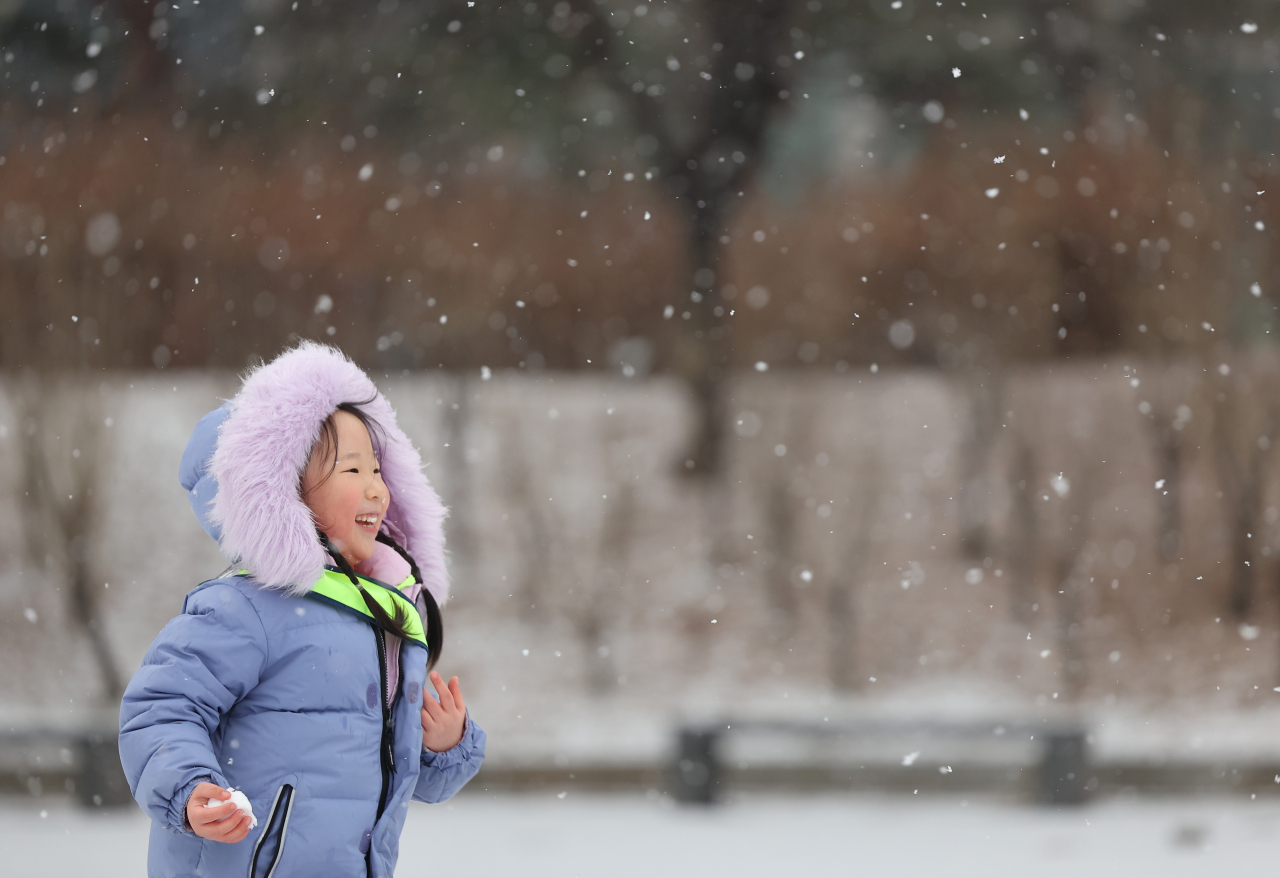 서울 전역에 대설주의보가 발효된 9일 오전 서울 영등포구 여의도공원에서 어린이들이 눈을 보며 즐거워하고 있다.[연합]
