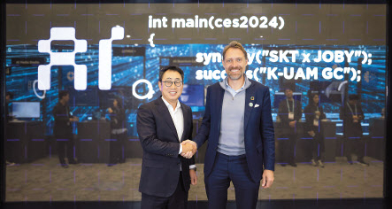 유영상 SK텔레콤 사장(사진 왼쪽), Joby Aviation 조벤 비버트 CEO(사진 오른쪽)가 CES 2024에 마련된 ‘SK ICT 패밀리 데모룸’에서 기념 촬영을 하고 있다. [SK텔레콤 제공]