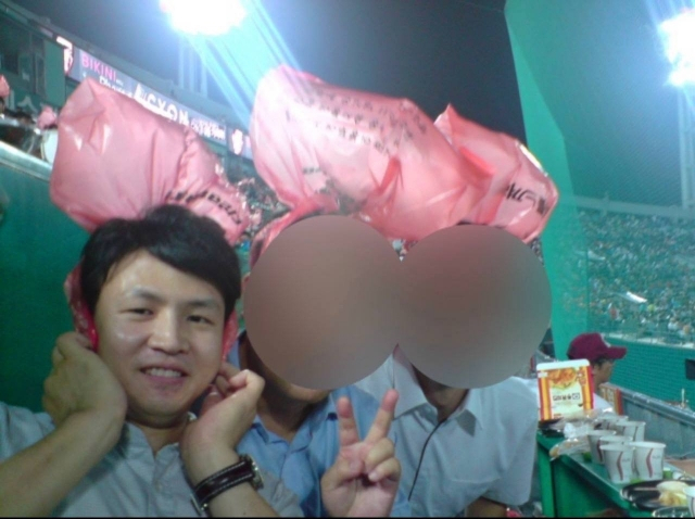 국민의힘이 12일 공개한 한동훈 비상대책위원장의 10여년 전 과거 사진. 부산 사직구장에서 머리에 비닐을 쓰고 응원전을 하고 있다. [국민의힘 공보실 제공]