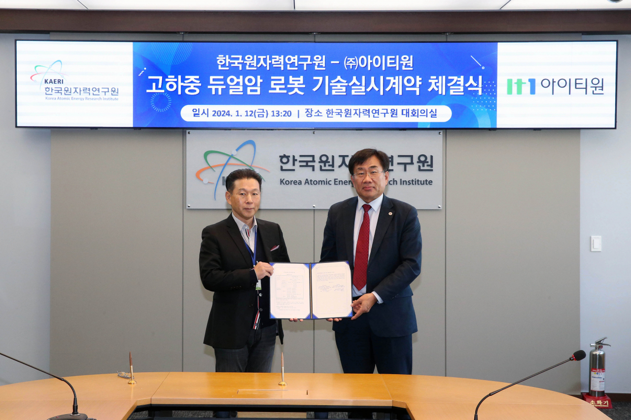 주한규(오른쪽) 한국원자력연구원 원장과 김영평 (주)아이티원 대표이사가 기술이전 협약서를 들어보이고 있다.[한국원자력연구원 제공]