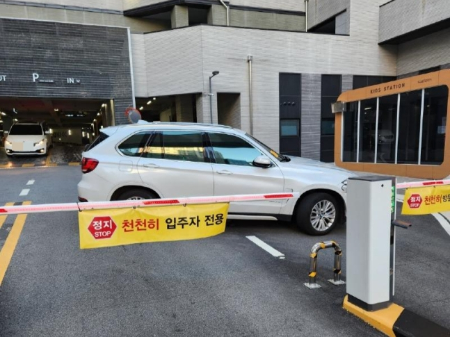부산의 한 아파트 주민이 주차장 차단기를 막고 차를 세운 모습. [온라인 커뮤니티 캡처]