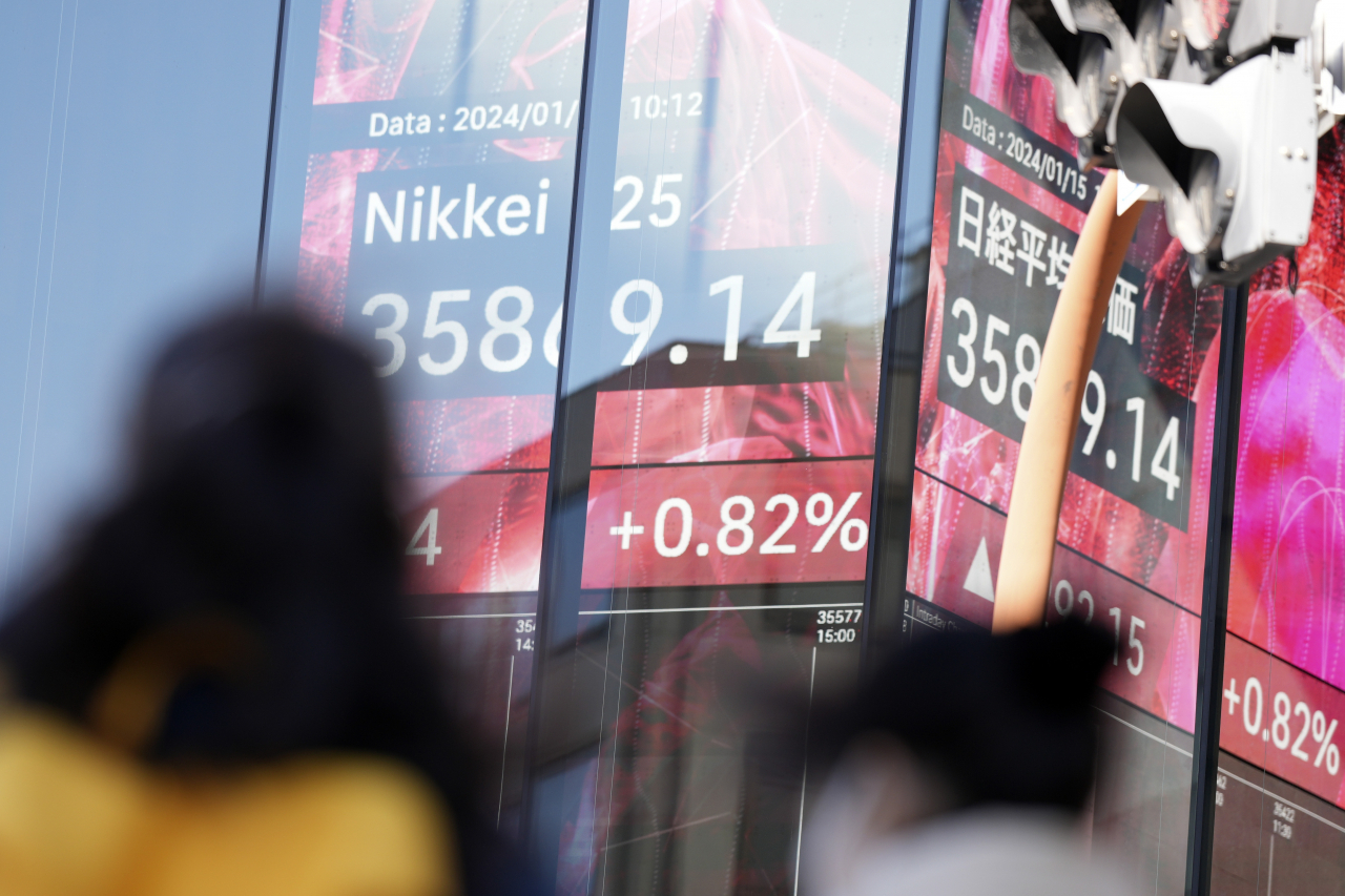 15일 일본 도쿄의 증권사 전광판 앞에 사람들이 지나가고 있다. [사진=AP]
