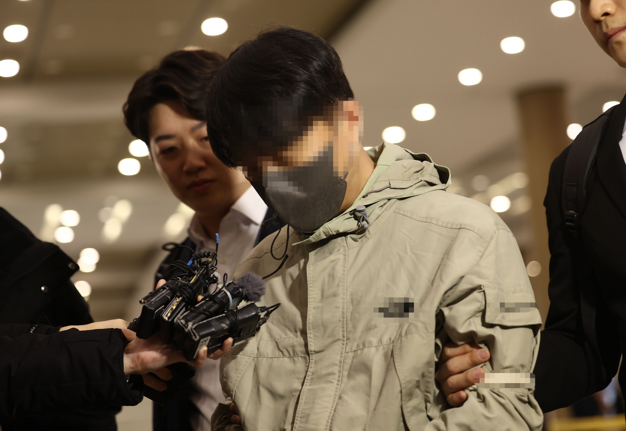 국민건강보험공단 재정관리팀장으로 재직하며 총 46억원을 횡령한 혐의를 받는 최모 씨가 필리핀 현지에서 검거된 뒤 17일 오전 인천국제공항 1터미널을 통해 국내로 송환되고 있다. [연합뉴스]