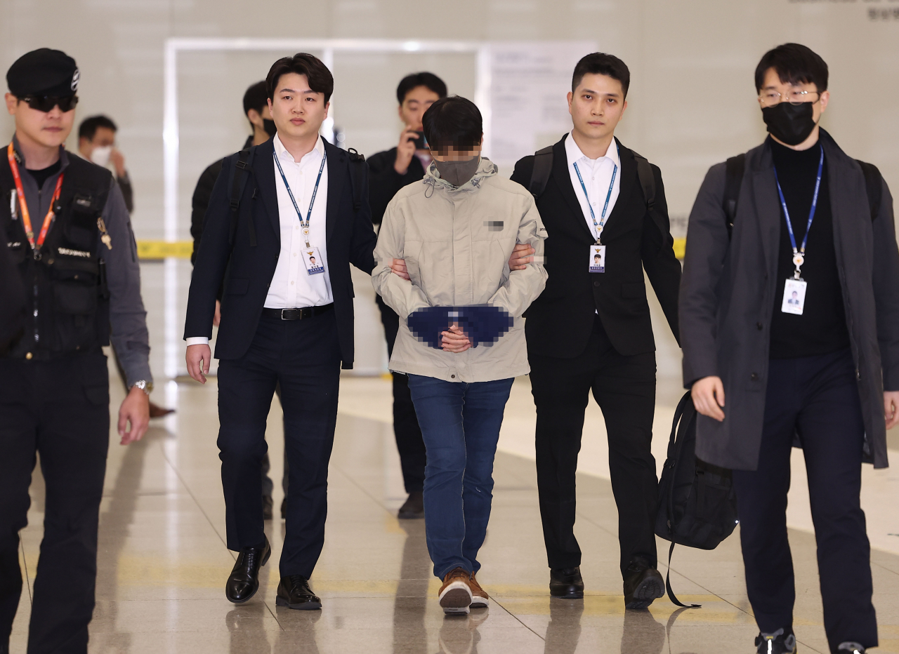 국민건강보험공단 재정관리팀장으로 재직하며 총 46억원을 횡령한 혐의를 받는 최모 씨가 필리핀 현지에서 검거된 뒤 17일 오전 인천국제공항 1터미널을 통해 국내로 송환되고 있다. [연합뉴스]