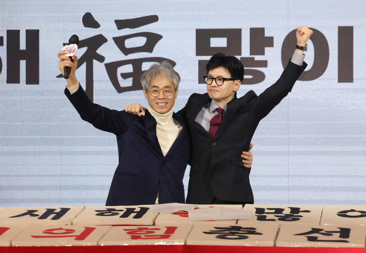 국민의힘 한동훈 비상대책위원장이 17일 오전 서울 마포구 케이터틀에서 열린 서울시당 신년인사회에서 김경율 비상대책위원과 손을 들어 올리고 있다. [연합]