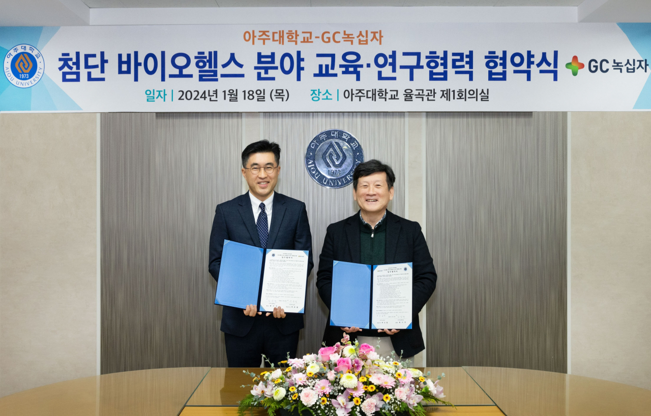 김용운 GC녹십자 인재경영실장(왼쪽)과 김경래 아주대 부총장(오른쪽)이 MOU를 체결하고 함께 기념 촬영을 하고 있다.[GC녹십자 제공]