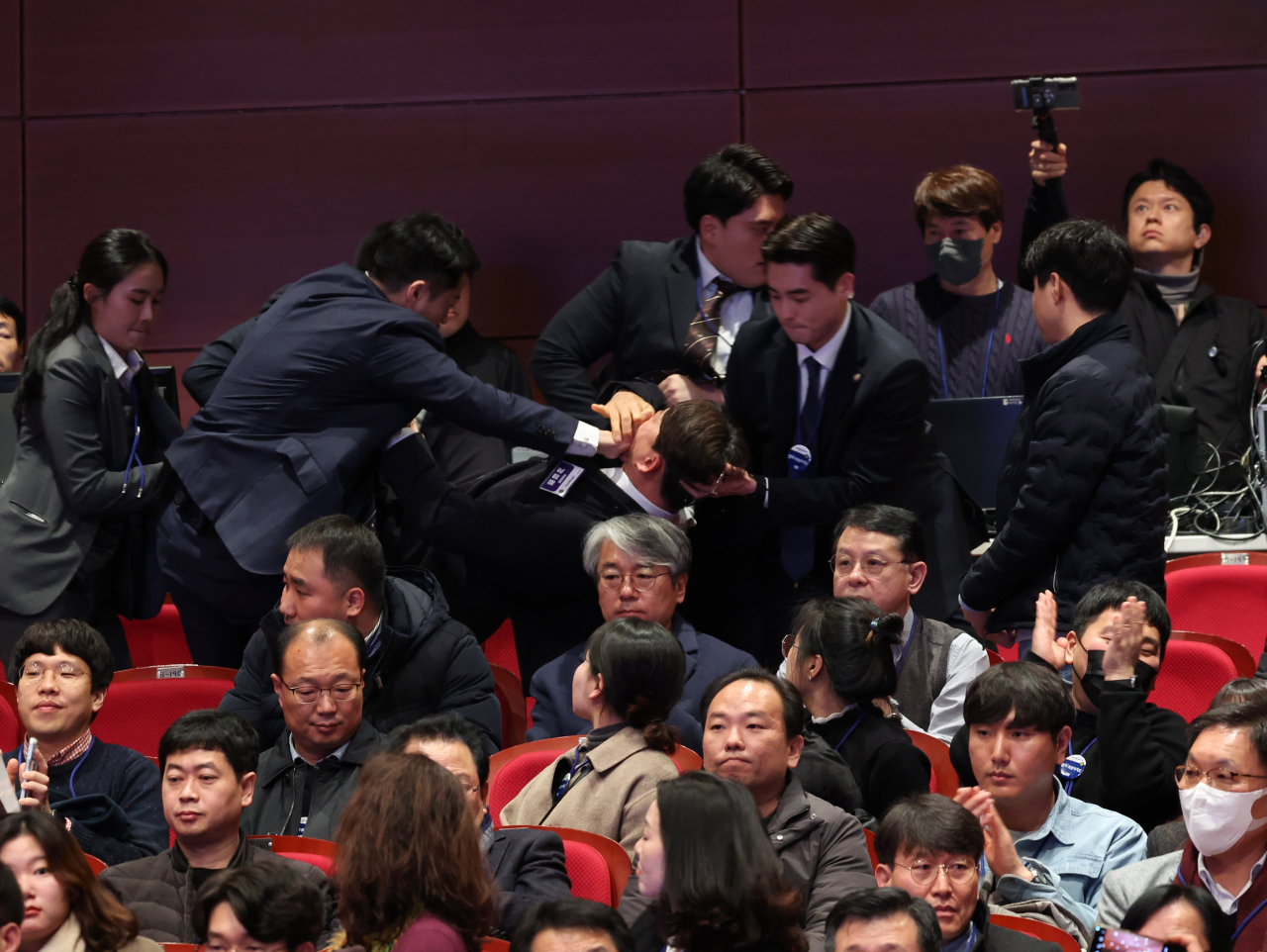 강성희 진보당 의원이 지난 18일 전주시 덕진구 한국소리문화의전당 모악당에서 열린 전북특별자치도 출범식에서 윤석열 대통령이 입장하며 참석자들과 악수하는 동안 경호원들에게 제지당해 끌려나가고 있다. 진보당측은 “강 의원이 윤 대통령과 악수하며 ‘국정기조를 바꾸지 않으면 국민들이 불행해집니다’라는 말을 건넨 순간 경호원들이 제지했다”고 주장했다. [연합]