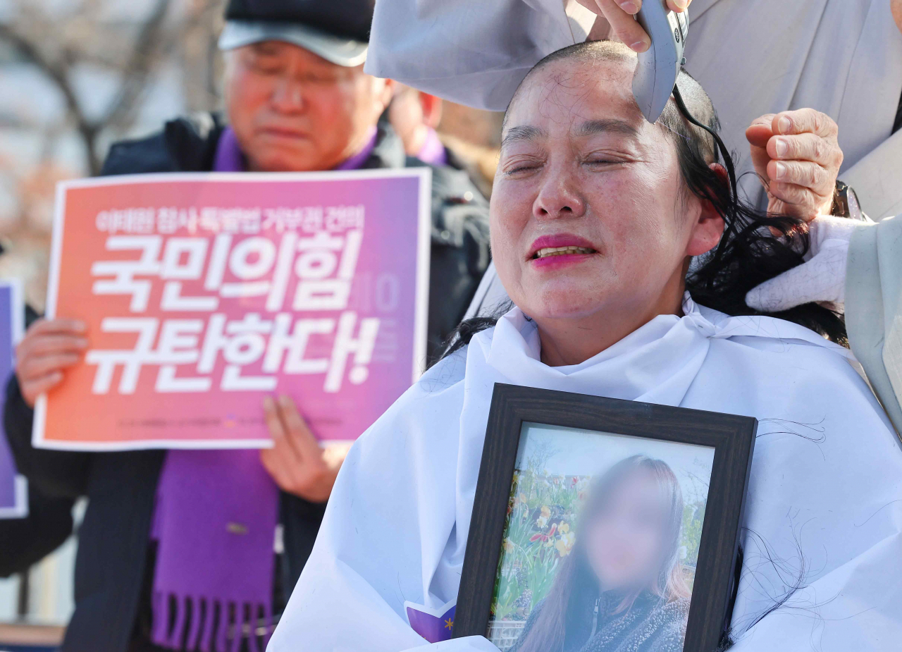 10.29 이태원 참사 유가족이 18일 오후 서울 용산구 대통령실 인근에서 국민의힘이 이날 의결한 이태원 참사 진상규명 특별법에 대한 대통령 거부권 행사 건의를 규탄하며 삭발하고 있다. [연합]
