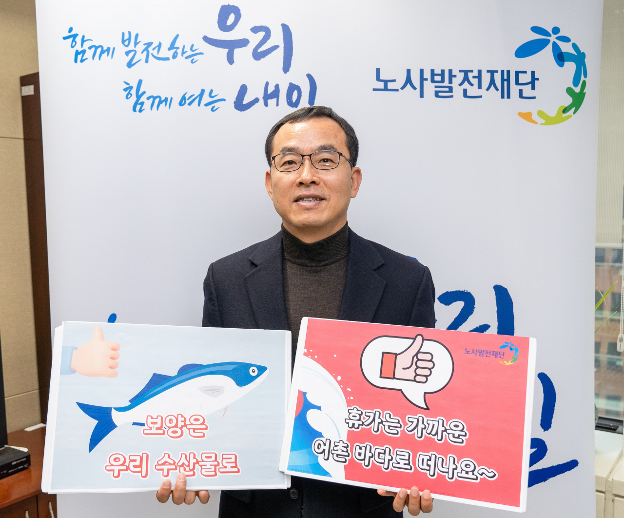 김대환 노사발전재단 사무총장이 ‘수산물 소비 및 어촌휴가 장려 캠페인’에 참여하고, 기념사진을 촬영하고 있다. [노사발전재단 제공]