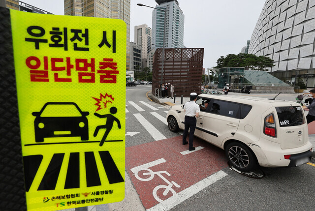 지난해 7월12일 서울 송파구 잠실역 교차로에서 송파경찰서 경찰관들이 우회전 일시정지 계도 활동을 하고 있는 모습. [연합]