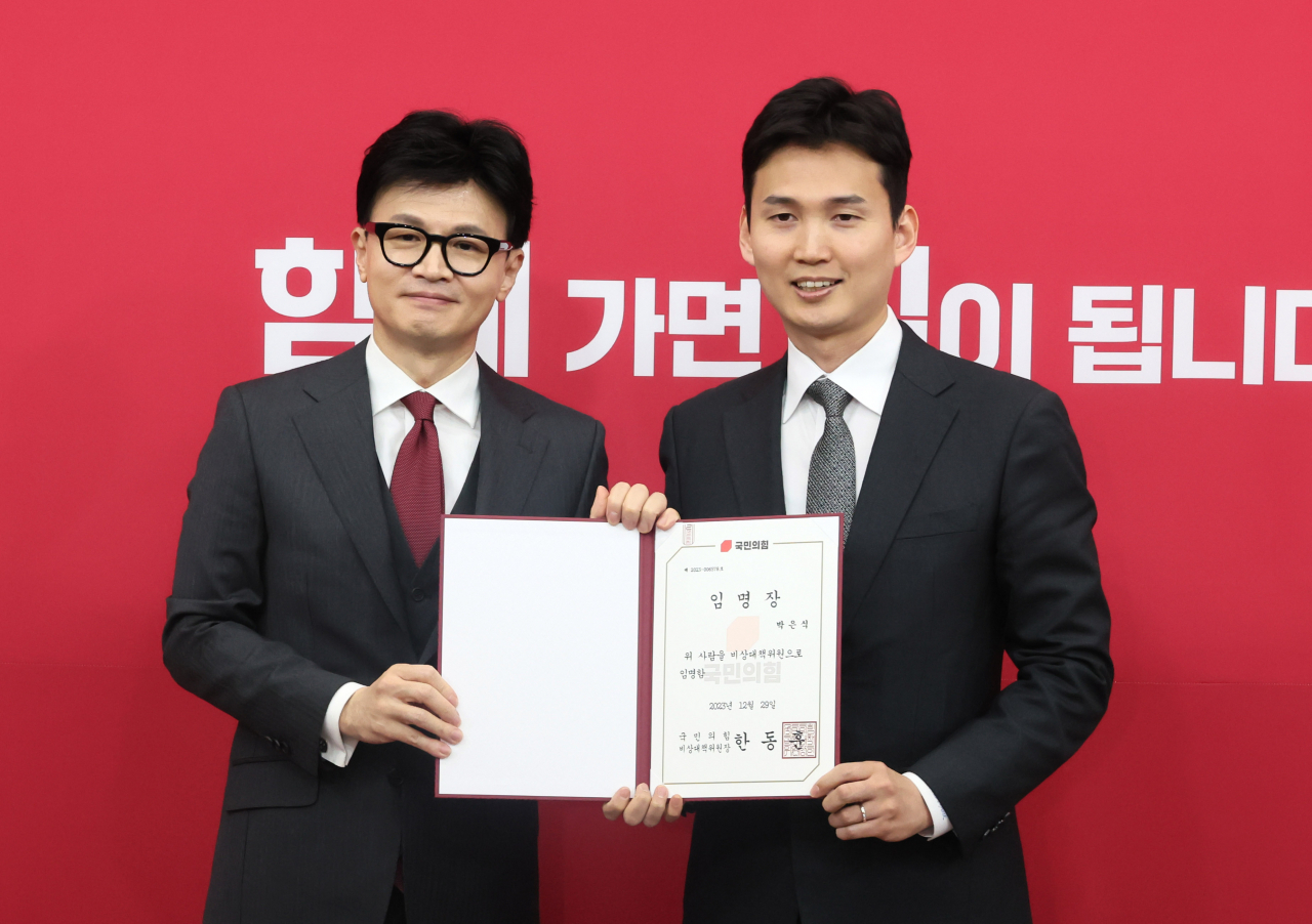 국민의힘 한동훈 비상대책위원장이 29일 국회에서 열린 비상대책위원 임명장 수여식에서 박은식 비대위원에게 임명장을 수여한 뒤 포즈를 취하고 있다.[연합]