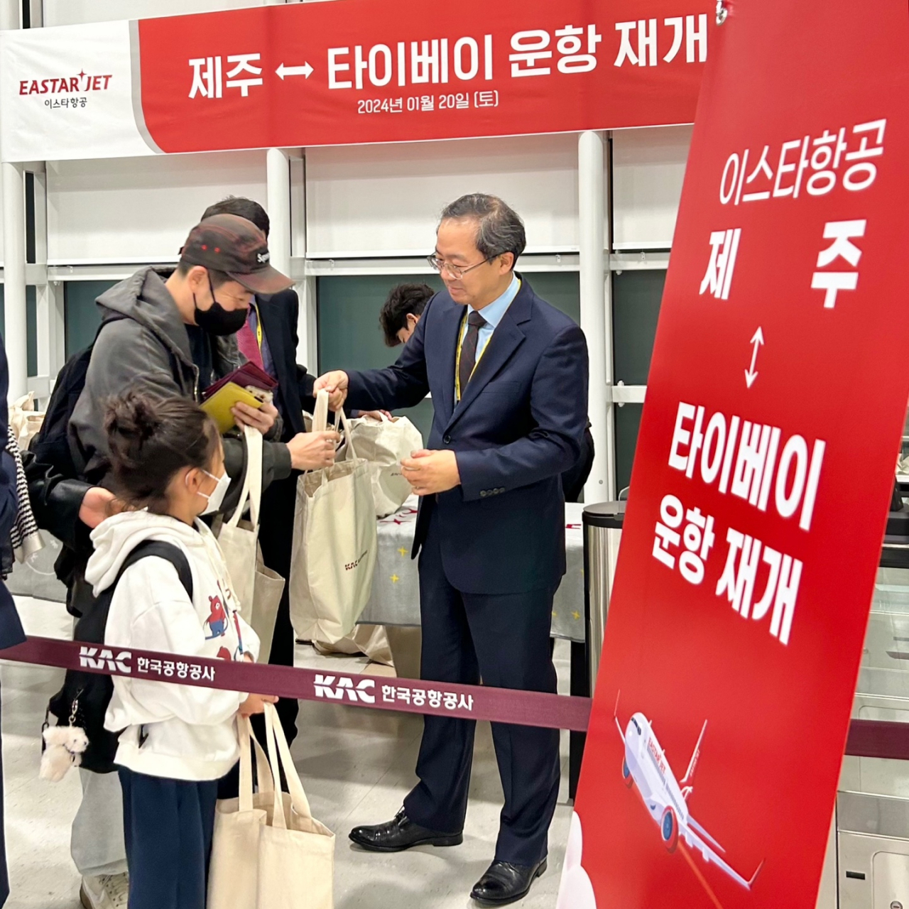 조중석 이스타항공 대표가 지난 20일 제주국제공항에서 첫 편(ZE885) 탑승객들에게 선물을 나눠주고 있다. [이스타항공 제공]