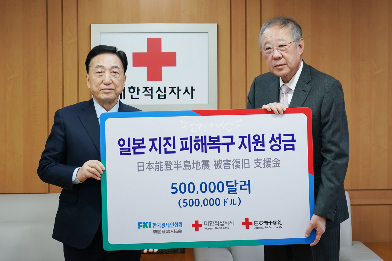 류진(오른쪽) 한국경제인협회 회장이 22일 중구 대한적십자사를 방문해 김철수(왼쪽) 대한적십자사 회장에게 일본 지진 피해 복구 성금 50만 달러(약 6억7000만원)를 전달했다. [한경협 제공]