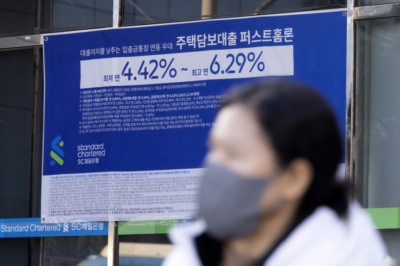 서울 한 시중은행 영업점의 대출 안내문 앞을 시민이 지나가고 있다.[연합]