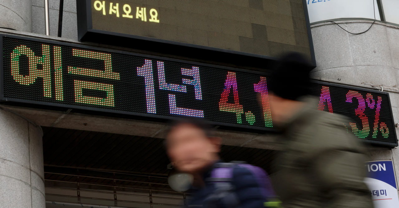 서울 시내 한 은행 금리 안내 전광판 앞을 시민들이 지나가고 있다. [연합]