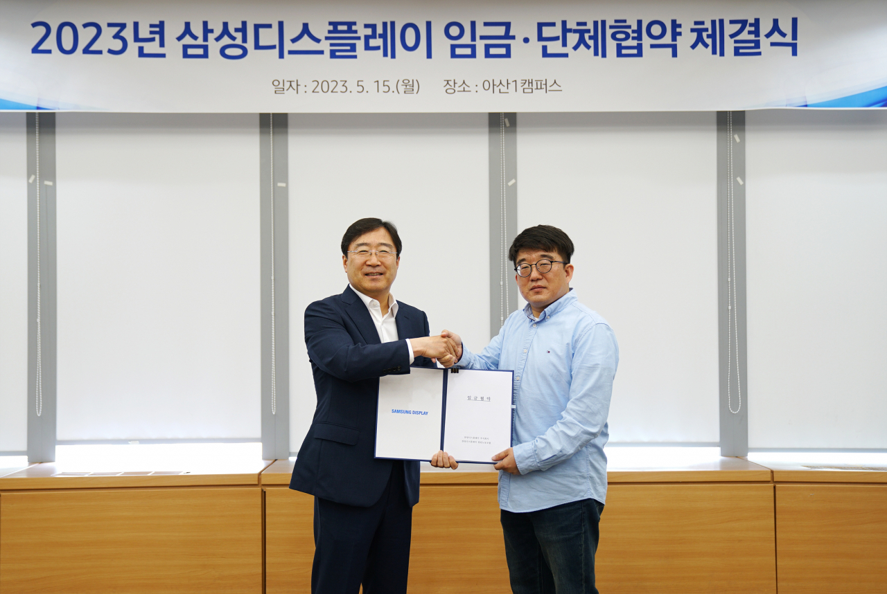 지난해 5월 삼성디스플레이 아산캠퍼스에서 열린 ‘2023년 임금·단체협약 체결식’에 참석한 윤성희(왼쪽) People팀장(부사장)과 유하람 열린노동조합 위원장이 기념사진을 촬영하고 있다. [삼성디스플레이 제공]