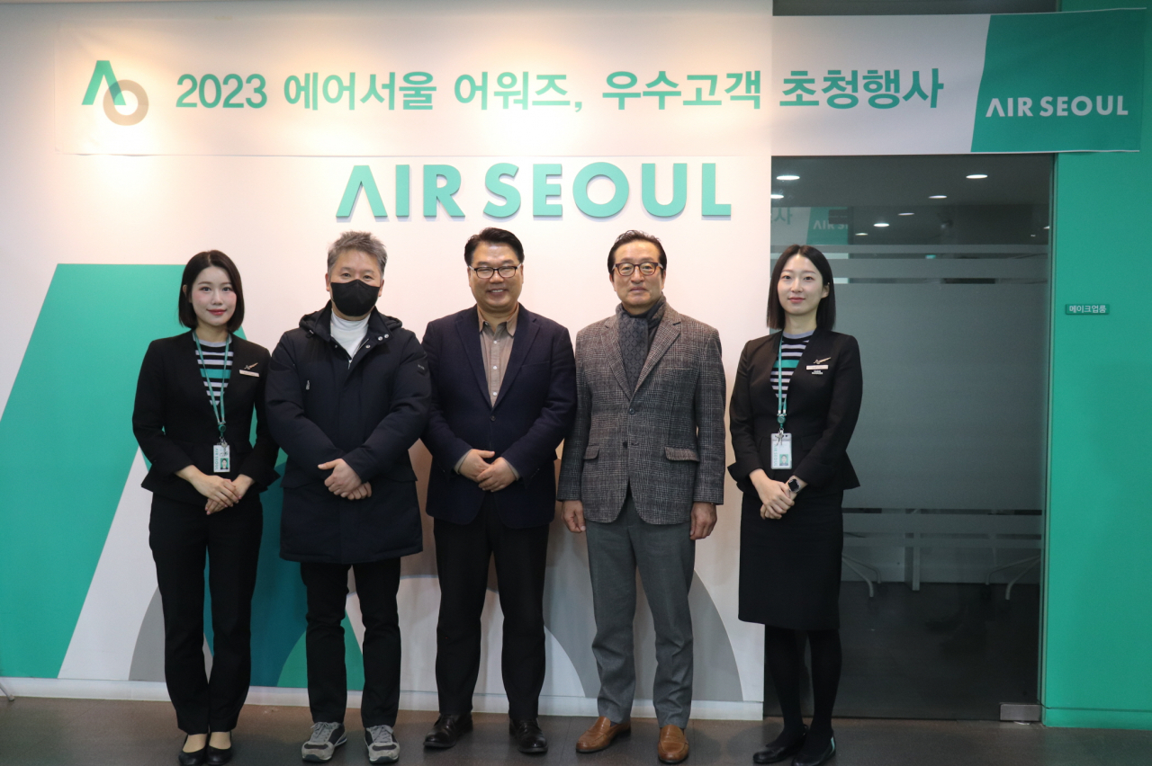 조진만(가운데) 에어서울 대표이사와 승무원, 우수고객 초청대상자들이 기념 촬영을 하는 모습. [에어서울 제공]