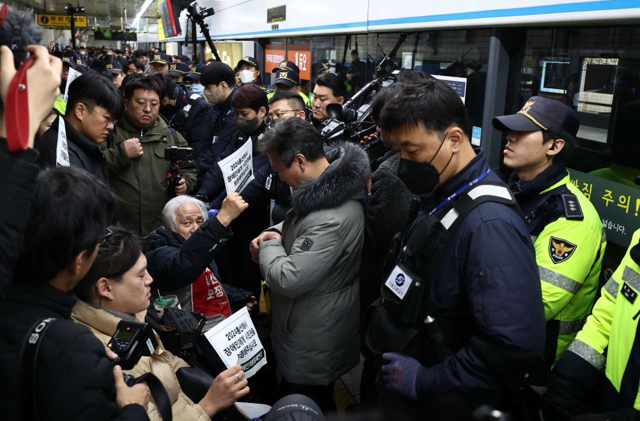 박경석 전국장애인차별철폐연대(전장연) 대표를 비롯한 참석자들이 지난 2일 오전 서울 종로구 혜화역 승강장에서 열린 출근길 지하철 탑승 시위에서 시민권 보장등 요구 사항이 적힌 손 피켓을 들어보이고 있다. [연합]