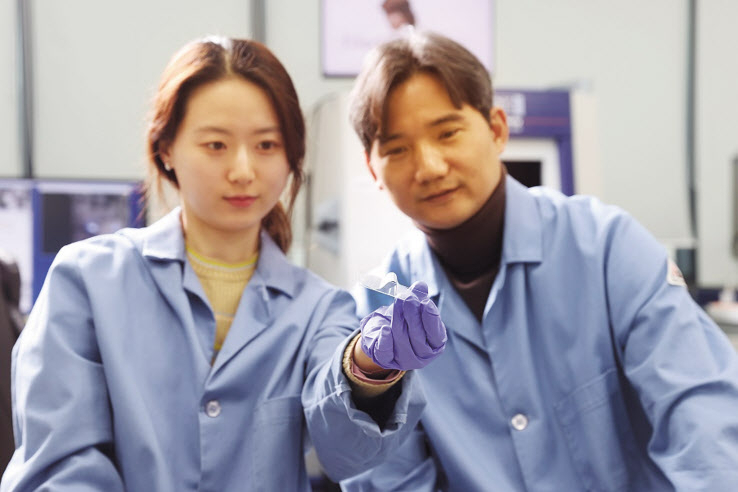 KAIST 신소재공학과의 홍승범(오른쪽) 교수와 주소연 박사과정생이 뼈 재생을 가속화시키는 생체모방지지체를 들어보이고 있다. [KAIST 제공]