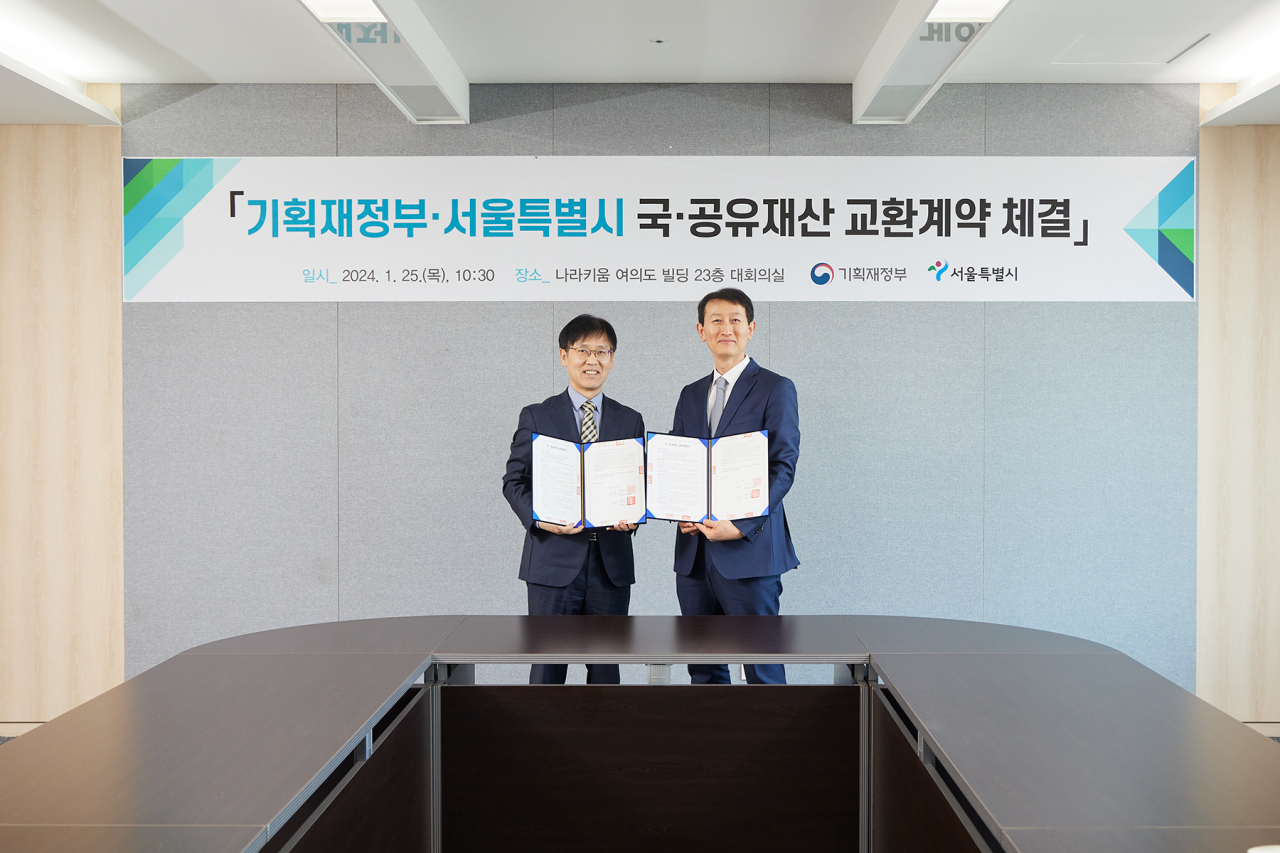25일 나라키움 여의도빌딩에서 열린 기획재정부와 서울시 간 국공유재산 교환계약 체결식에서 김진만 서울시 재무국장(왼쪽)과 임형철 기획재정부 국고국장이 기념 촬영을 하고 있다. [서울시 제공]
