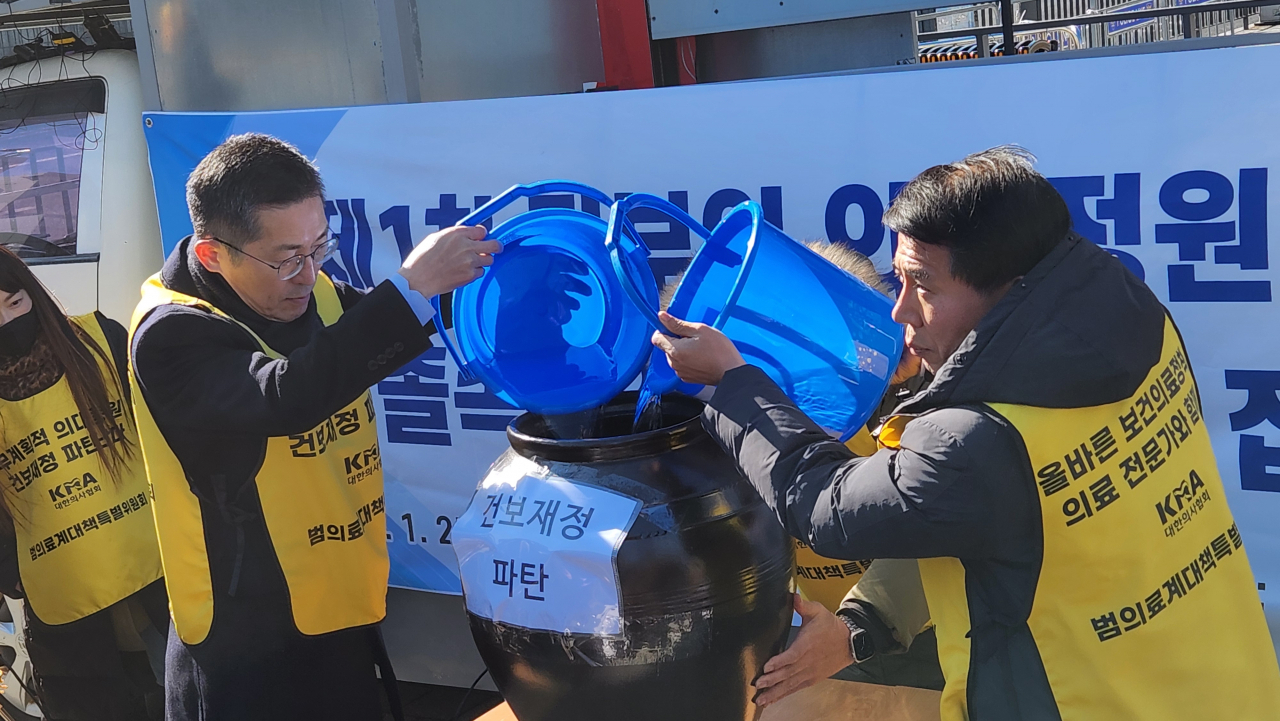 25일 ‘제1차 정부의 의대 정원 증원 졸속 추진 강력 규탄 집회’에서 이필수 범대위원장(의협 회장)이 ‘건보재정 파탄’이라는 문구가 적힌 항아리에 물을 붓는 퍼포먼스를 보이고 있다. 안효정 기자