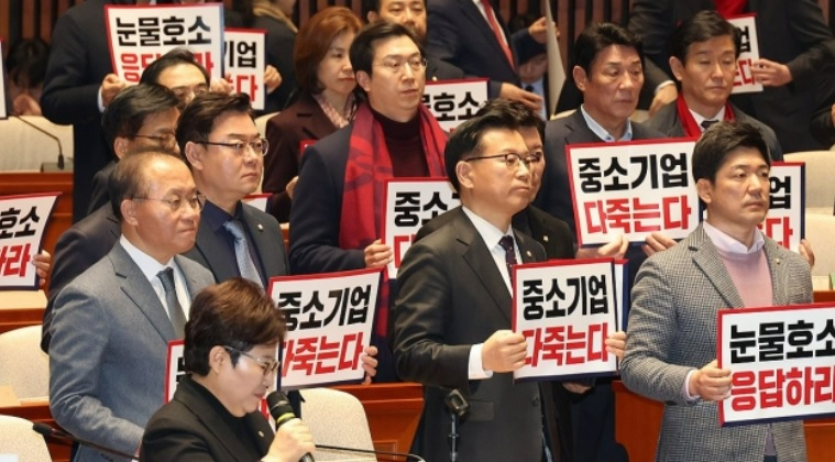 지난 25일 국회에서 열린 국민의힘 의원총회에서 윤재옥 원내대표 등 참석자들이 중대재해처벌법 유예를 촉구하는 구호를 외치고 있다.[연합]