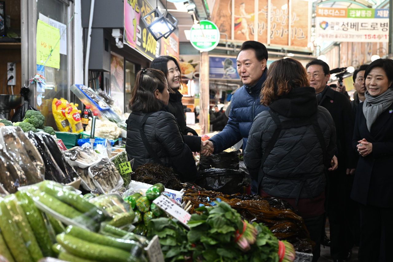 윤석열 대통령이 지난 25일 경기도 의정부시 의정부제일시장을 찾아 상인들을 격려하고 있다. [연합]