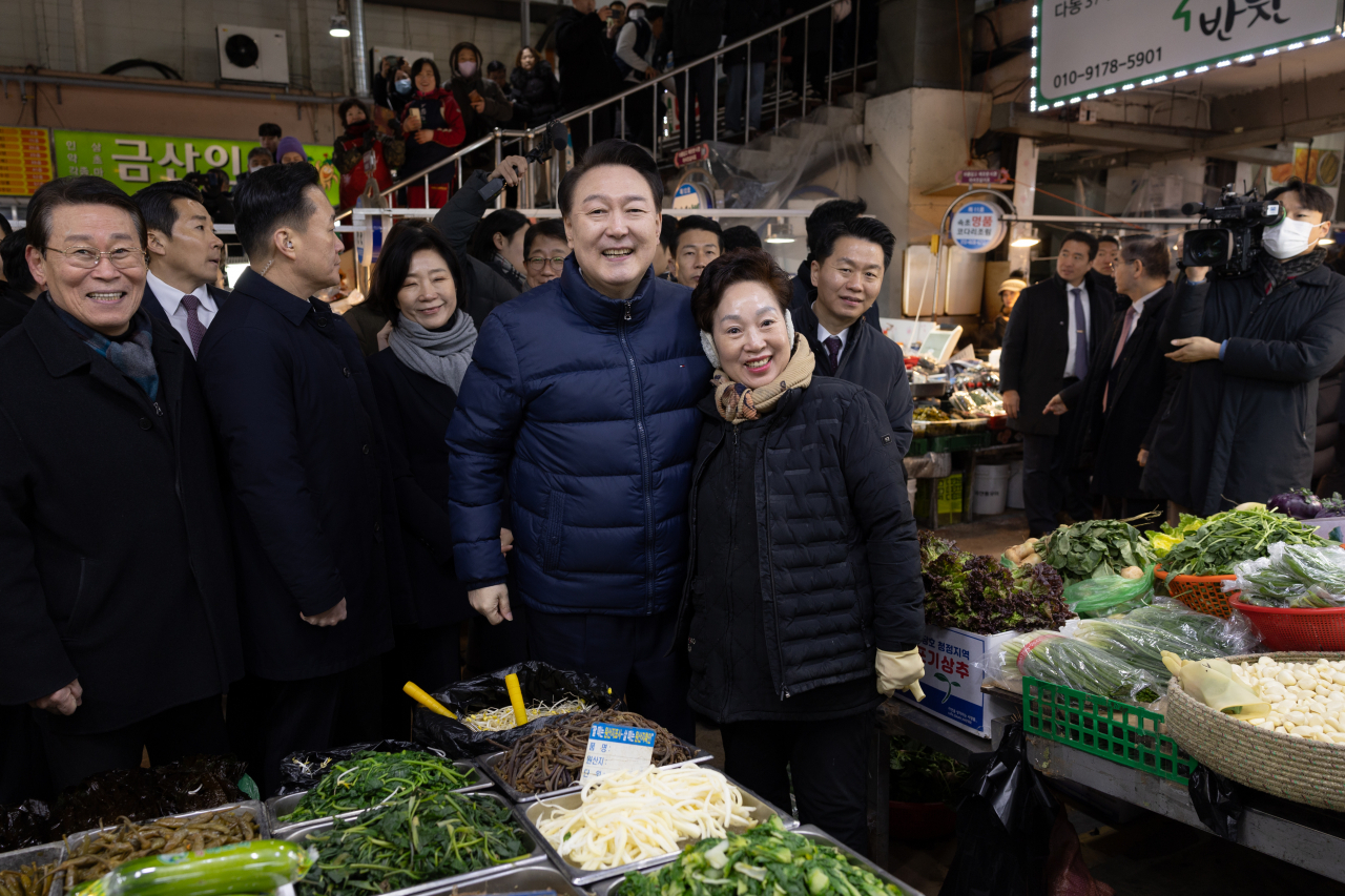 윤석열 대통령이 25일 경기도 의정부시 의정부제일시장에서 한 상인과 기념 촬영을 하고 있다. [연합]