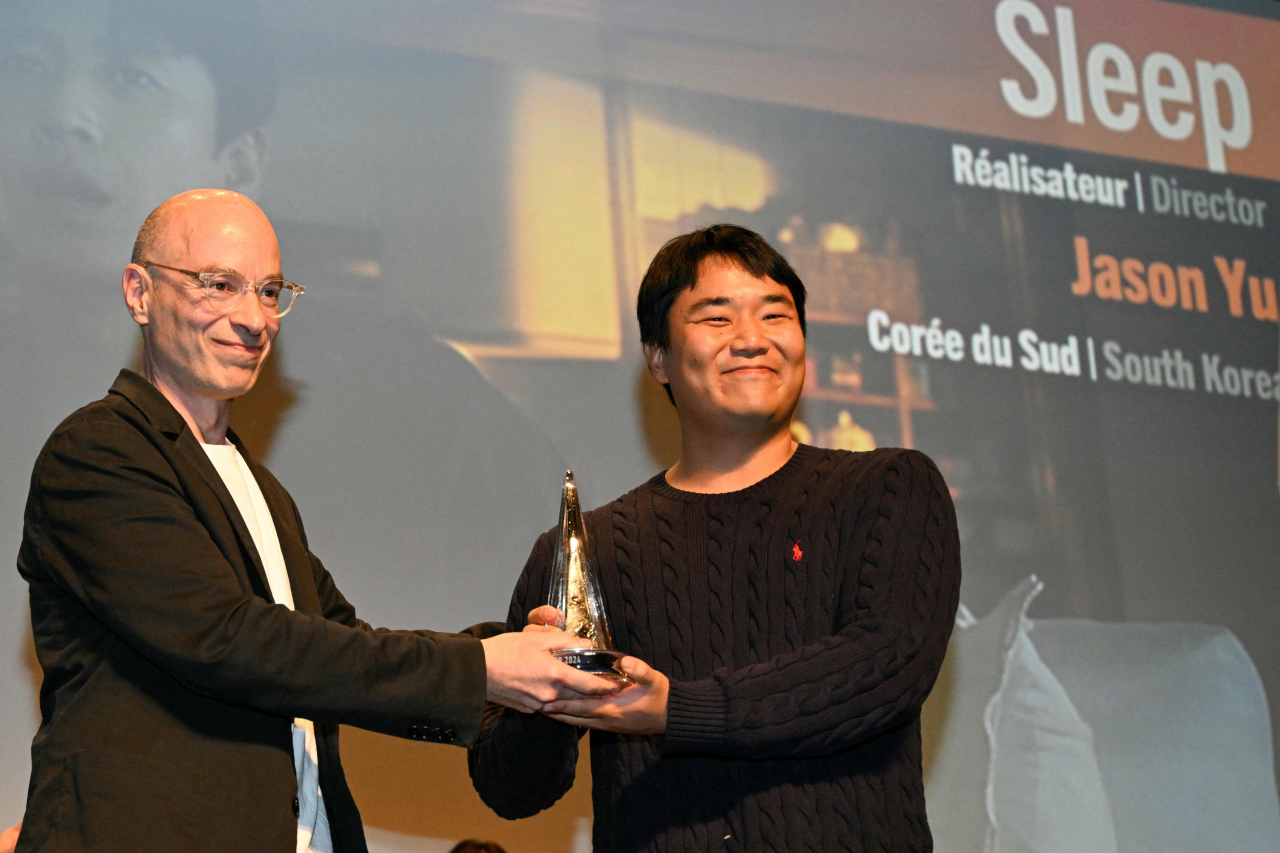 South Korean director Jason Yu (right) poses with French author, journalist and director, president of the feature film jury, Bernard Werber after winning the Grand prize for the film "Sleep" during the closing ceremony of the 31st Gerardmer Fantastic Film Festival in Gerardmer, France, Sunday. (AFP-Yonhap)