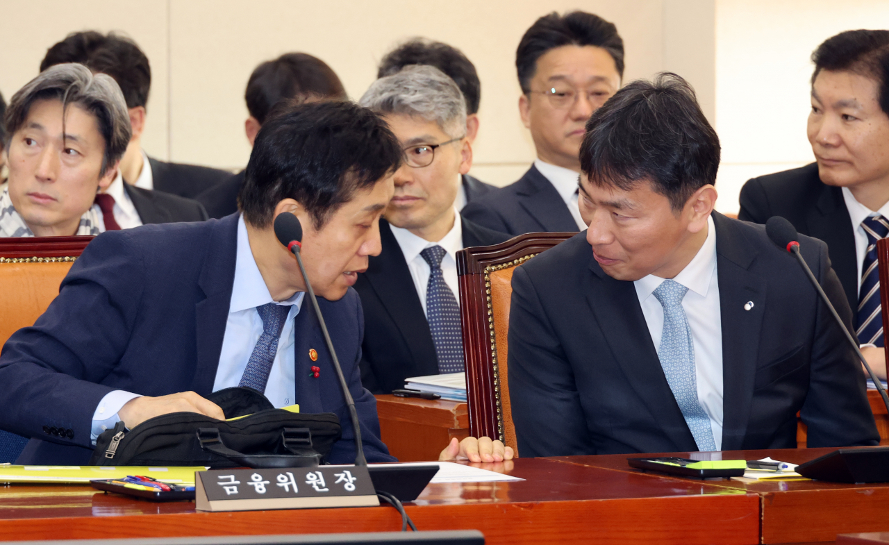 김주현 금융위원장과 이복현 금융감독원장이 29일 국회 정무위원회에서 대화하고 있다. [연합]