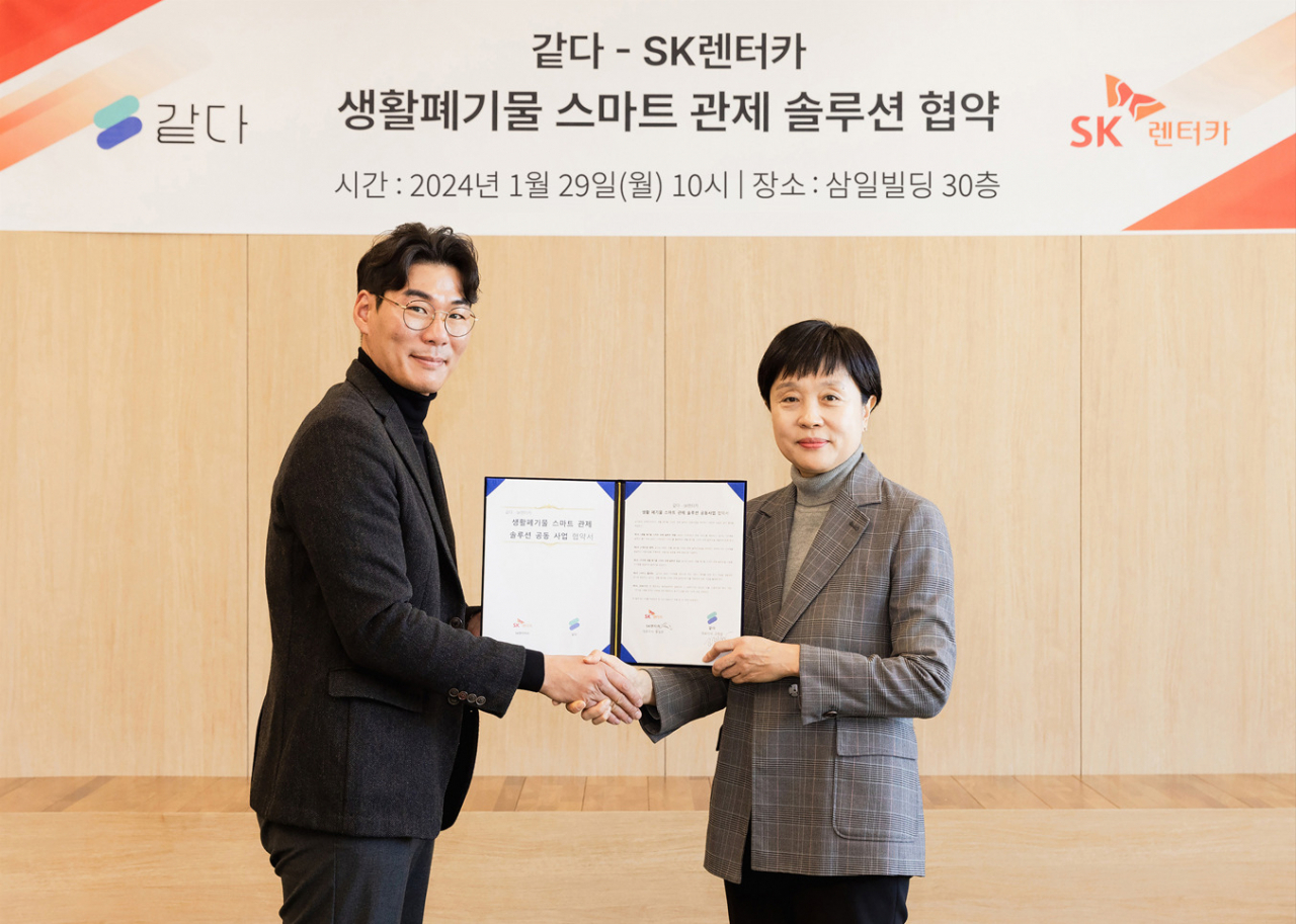 류성희(오른쪽) SK렌터카 경영지원본부장과 고재성 같다 대표이사가 지난 29일 서울 종로구 삼일빌딩에서 ‘생활폐기물 스마트 관제 솔루션 공동사업을 위한 업무협약’을 체결하고 기념사진을 촬영하고 있다. [SK렌터카 제공]