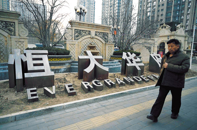 지난 29일 중국 베이징에서 ‘에버그란데 팰리스’라는 이름의 헝다그룹 아파트 단지를 한 시민이 지나가고 있다. [AFP]