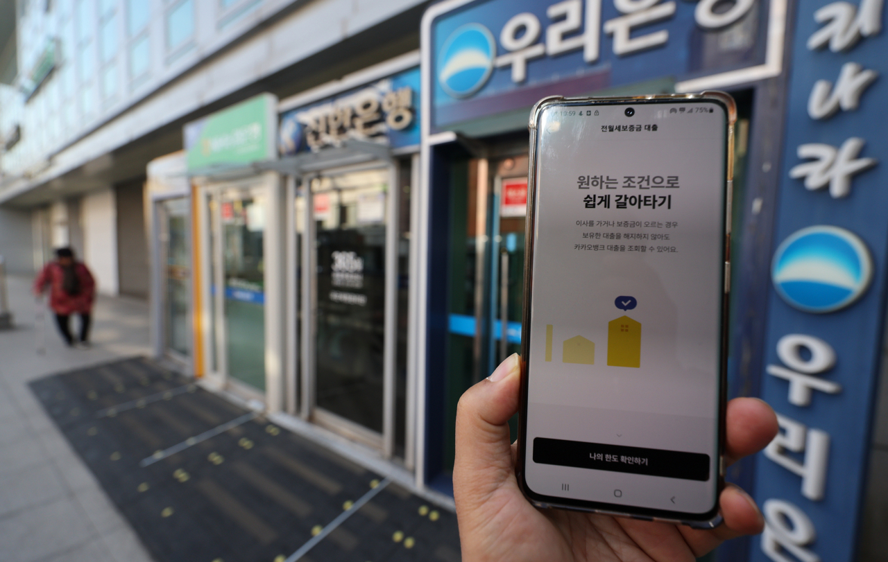 오는 31일부터 신용·주택담보대출에 이어 전세대출 갈아타기도 가능해진다. 금융위원회는 서민·무주택자의 주요 주거금융상품인 전세대출 갈아타기 서비스를 개시한다고 30일 밝혔다. 사진은 휴대전화 뱅킹앱과 서울 시내 거리의 은행 현금자동입출금기. [연합]