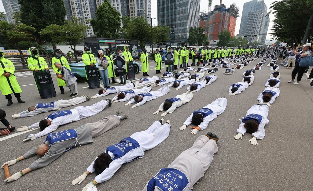 지난해 6월 14일 서울 용산구 한강대로에서 전국장애인부모연대, 대한불교조계종 사회노동위원회 관계자 등이 발달장애인 전 생애 권리기반 지원체계 구축을 촉구하며 대통령실 방향으로 오체투지를 하고 있다.[연합]